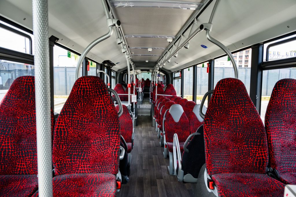Photograph of the interior of a CFL bus. The seats are upholstered in red fabric.